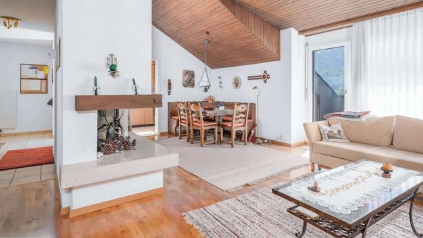 A spacious living area with a fireplace, dining table, and a sofa. - Charming Alpine Apt with View, 5min to Interlaken Ost (Interlaken)