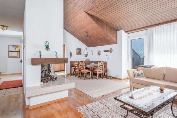 A spacious living area with a fireplace, dining table, and a sofa. - Charming Alpine Apt with View, 5min to Interlaken Ost (Interlaken)