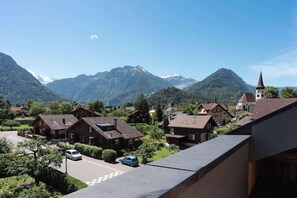 A residential area with houses, a church, and mountains in the background. - Charming Alpine Apt with View, 5min to Interlaken Ost (Interlaken)