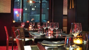 Een restaurant met gedekte tafels, uitzicht vanuit het raam en hangende吊灯.