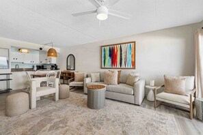 Ein modernes Wohnzimmer mit Sofa, Sesseln, Couchtisch und einer Essecke mit Tisch und Stühlen.