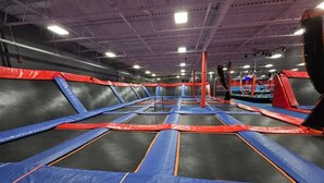 Ein großer Indoor-Trampolinpark mit zahlreichen Trampolinen und Sicherheitsauflagen.