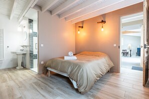 Ein Schlafzimmer mit einem Bett, einem Nachttisch und einem Badezimmer mit einem Waschbecken.