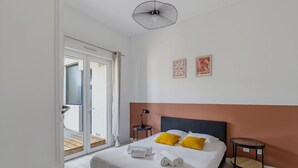 A bedroom with a bed, a bedside table, a lamp, and a ceiling fan. - Le Spatiozo - Appt aux Abatilles, proche plage (Arcachon)