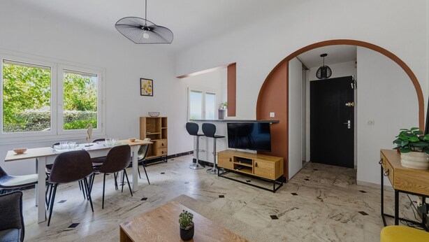 A modern interior with a dining area, a TV, and a plant. - Le Spatiozo - Appt aux Abatilles, proche plage (Arcachon)
