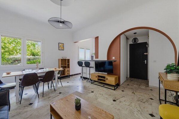 Ein modernes Interieur mit Essbereich, Fernseher und einer Pflanze.