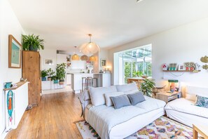 Ein modernes Schlafzimmer mit einem großen Bett, einem Schreibtisch und Blick ins Freie.