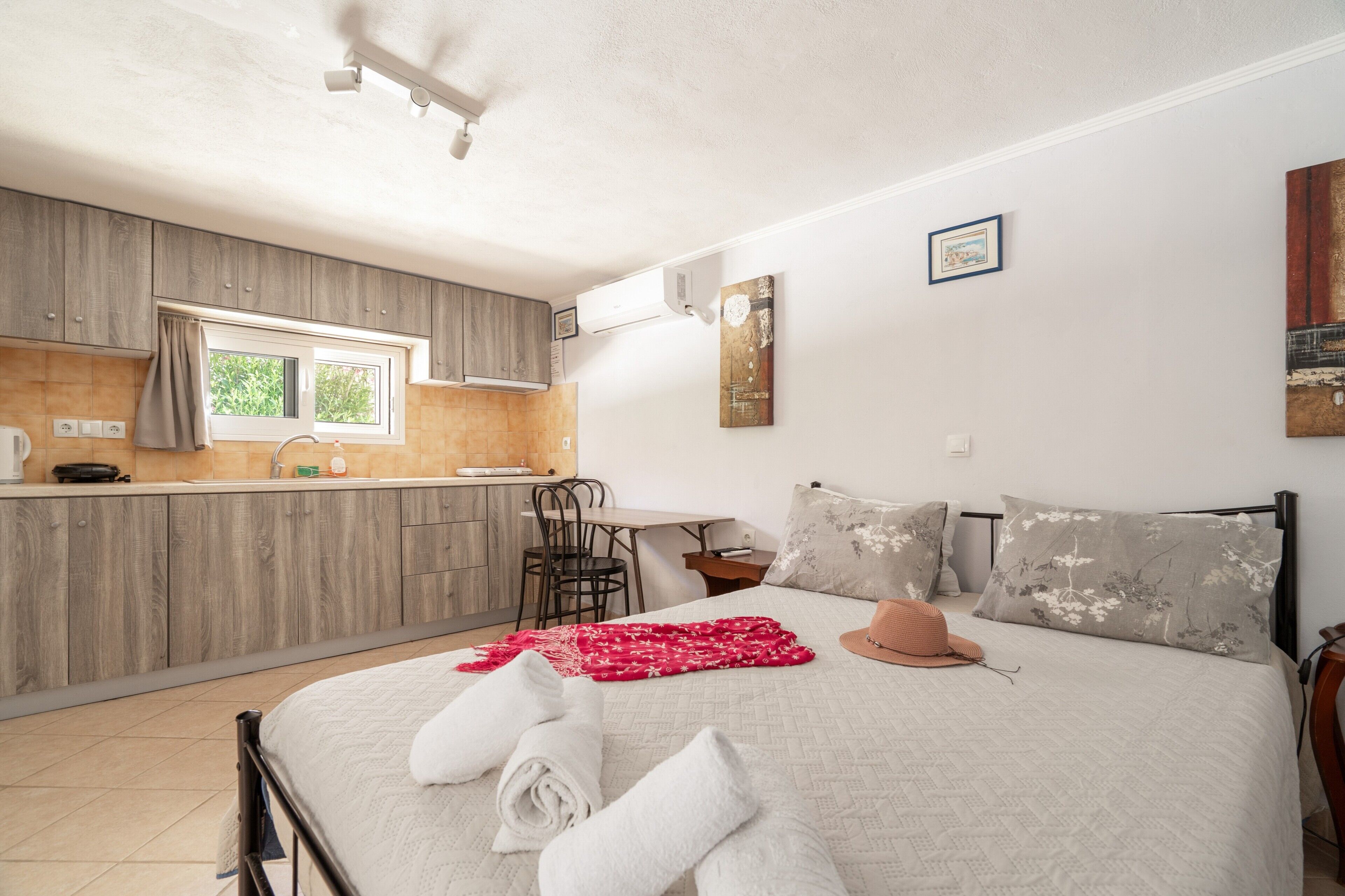 Une chambre à coucher avec un lit, des oreillers, un chapeau et des serviettes.