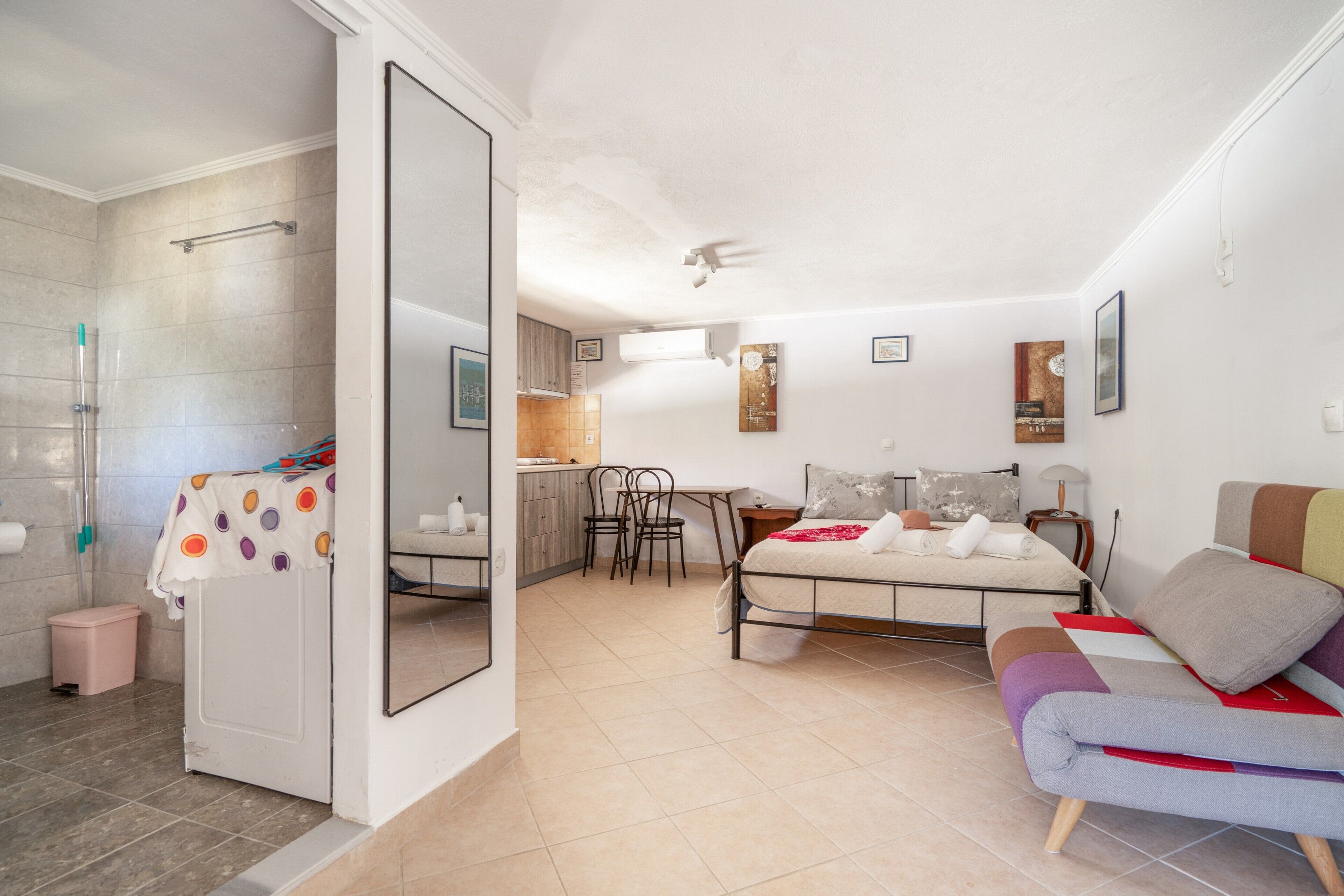 Une chambre à coucher comprenant un lit, une chaise, une petite table et une salle de bain avec douche.