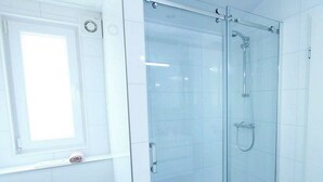 A bathroom with a glass-enclosed shower, a toilet, and a window. - Holiday Home in Nijkerk With Terrace (Nijkerk)
