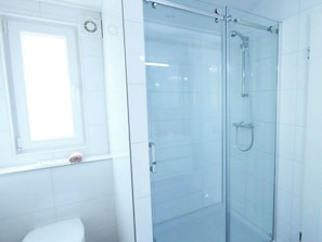 A bathroom with a glass-enclosed shower, a toilet, and a window. - Holiday Home in Nijkerk With Terrace (Nijkerk)