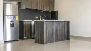 Eine moderne Küche mit integrierter Kochinsel, Edelstahlgeräten und einem minimalistischen Design.