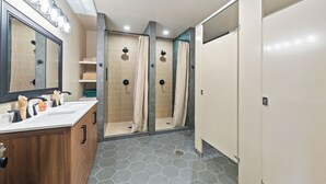 Une salle de bain moderne comprenant un meuble-lavabo, un espace douche et des toilettes.