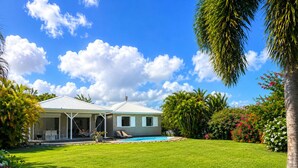 Uma casa com alpendre, piscina e vegetação exuberante.