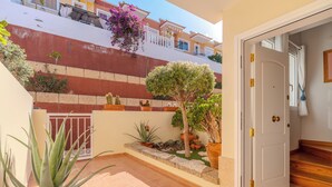 A courtyard with potted plants, a door, and a tiled floor. - Cozy 2-bedroom Apartment With Garden View in Costa Adeje (Adeje)