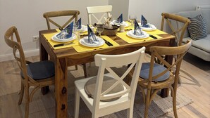 A dining area with a wooden table set for four, surrounded by wooden chairs with cushioned seats. - Eli and Eli 1 Vacation Rental in the Heart of Berlin / Near Alexanderplatz (Berlin)