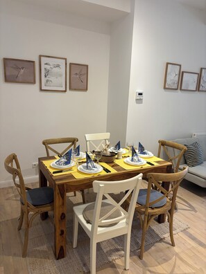 A dining area with a wooden table set for four, surrounded by wooden chairs with cushioned seats. - Eli and Eli 1 Vacation Rental in the Heart of Berlin / Near Alexanderplatz (Berlin)