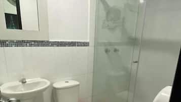 Een douche, handdoeken, zeep, toiletpapier