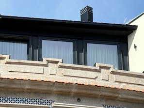 Ein Gebäude mit einer Stein-Fassade, einem Ziegeldach und einem Schornstein.