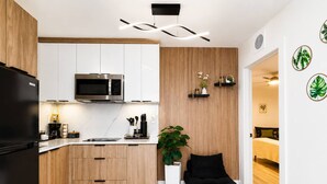 Una cocina moderna con microondas integrado, armarios de madera y encimera negra.