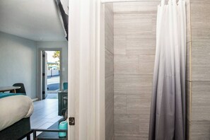 Ein Hotelzimmer mit Bett, einem kleinen Tisch und Blick auf die Straße.