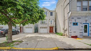 Une rue résidentielle bordée de maisons, avec un arbre et une voiture.