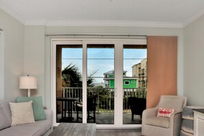 A living room with a sofa, armchair, and a table with chairs. - Summerhouse 206 - Brown Eyed Girl (Port St. Joe)