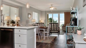 A kitchen with a dining area, a ceiling fan, and a view of the outdoors. - Summerhouse 206 - Brown Eyed Girl (Port St. Joe)