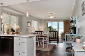 A kitchen with a dining area, a ceiling fan, and a view of the outdoors. - Summerhouse 206 - Brown Eyed Girl (Port St. Joe)