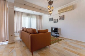 Ein Wohnzimmer mit einer Couch, Fernseher und Dekoration.
