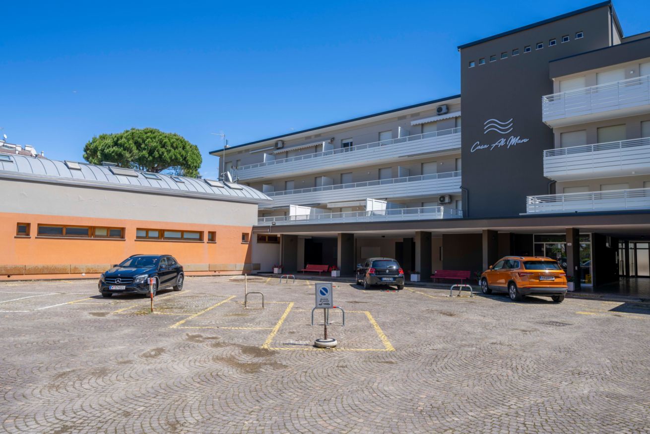 A hotel with a parking lot, multiple floors, and a sign indicating a no-parking zone.