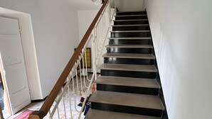 A staircase with a wooden handrail and white balusters, leading to an upper floor. - ‘Casa Vacanze Rita La California’ Apartment with Private Garden and Balcony (La California)