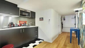 A compact kitchen with a microwave, toaster, and cabinets. - JUST A SHORT WALK FROM THE ICONIC CENTRE POMPIDOU- LE MARAIS (Paris)
