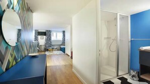 A modern bathroom with a glass shower enclosure, a sink, and a mirror. - JUST A SHORT WALK FROM THE ICONIC CENTRE POMPIDOU- LE MARAIS (Paris)