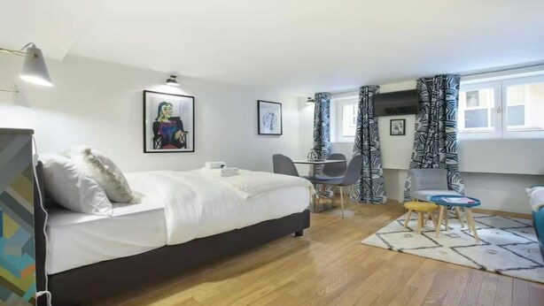 A modern hotel room with a bed, desk, chair, and a view of the outdoors. - JUST A SHORT WALK FROM THE ICONIC CENTRE POMPIDOU- LE MARAIS (Paris)
