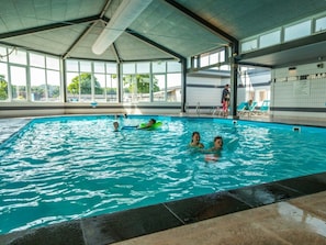 An indoor swimming pool with clear water, a tiled floor, and a covered roof structure. - Holiday Home in Noordwijk With Terrace (Noordwijk)