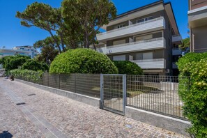 A multi-story residential building with balconies, a paved pathway, and a metal gate. - A comfortable 31 sqm studio apartment, perfect for two people, located on the third floor (Scala A) of a building with an elevator (NOT accessible to people with disabilities) directly facing the seafront.The property is located in Lignano Sabbiadoro in  (Lignano Sabbiadoro)