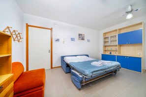 Ein Schlafzimmer mit einem Bett, einem Kleiderschrank, einem Schreibtisch und einem Stuhl.