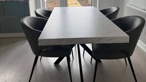 A dining area with a marble table and black chairs, a kitchen with a marble countertop, and a view through a glass door to an outdoor area. - Huge 4 Bed House with parking and garden! (Bristol)