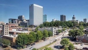 A cityscape with modern buildings, a prominent white skyscraper, and a historic building with a tower.