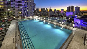Ein Pool auf dem Dach mit Blick auf eine Stadtlandschaft im Abenddämmerung.