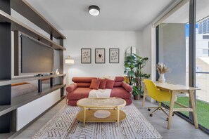 A modern living room with a sofa, a coffee table, a TV, and a desk. - Miami Bayside Balcony Studio Pool & Gym (Miami)