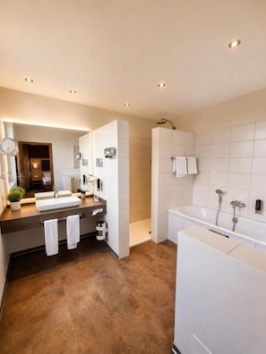 Une salle de bain moderne avec un meuble-lavabo à deux vasques, une baignoire et une douche.
