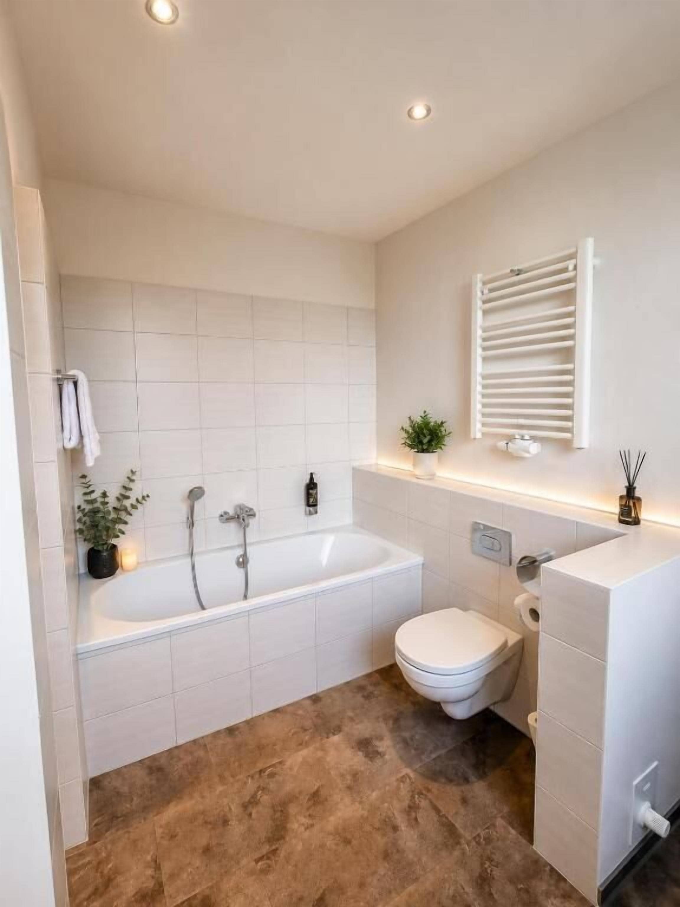 Un baño con bañera, inodoro y lavamanos blanco.