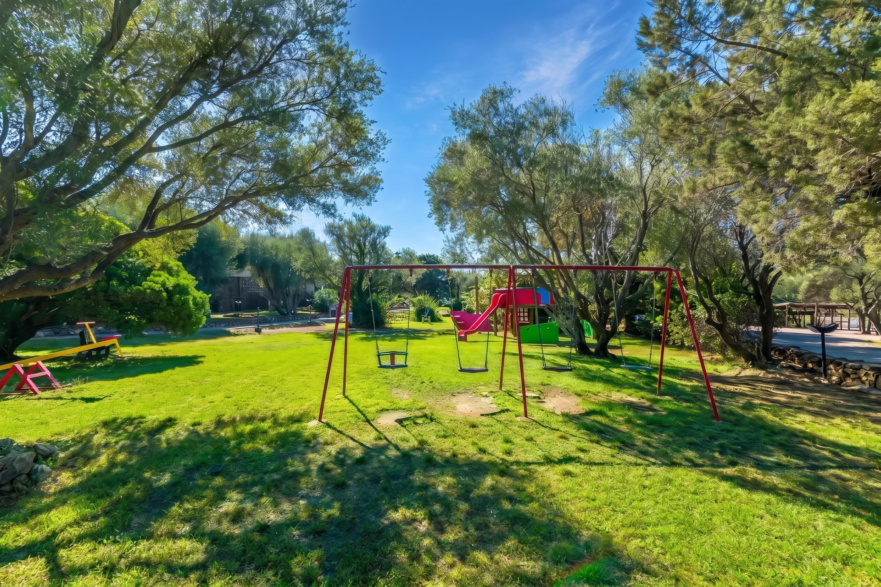 Ein Park mit Schaukeln, einer Rutsche und einem Picknickplatz.