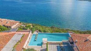 A rooftop pool with a clear view of the sea and distant mountains. - Nido Di Tom (Olbia)