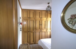 Ein Schlafzimmer mit Holzschränken, einem Bett und einer Pendelleuchte.