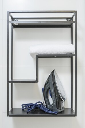 Een wandplank met een witte handdoek en een strijkijzer.