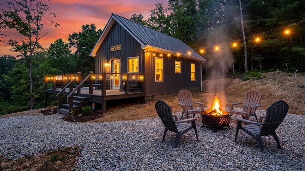 A cabin with a deck, a fire pit, and outdoor seating. - The Grey Squirrel Hideaway - Hot Tub , Fire-Pit, Pet-Friendly (Campton)