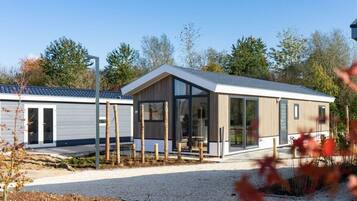 A modern single-story building with large windows, a flat roof, and a gravel driveway.